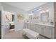 Bright bathroom with double vanity, stylish mirrors, tiled floors, and glass shower leading into bedroom at 438 Southland Cir, Canton, GA 30115