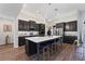 Modern kitchen showcasing dark cabinetry, a large central island with seating, and contemporary light fixtures at 438 Southland Cir, Canton, GA 30115