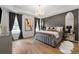 Luxurious main bedroom featuring a tray ceiling, elegant chandelier, and stylish accent wall at 438 Southland Cir, Canton, GA 30115