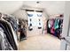 Spacious walk-in closet with ample hanging space, natural light, and neutral carpeting at 7860 Bristol Valley Dr, Cumming, GA 30028