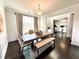 Dining room with a wooden table, bench seating, and wood floors, with views of an adjacent room at 7860 Bristol Valley Dr, Cumming, GA 30028