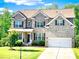 Charming two-story brick home with a well-manicured lawn and attached two car garage at 7860 Bristol Valley Dr, Cumming, GA 30028