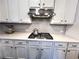 A well-organized kitchen with gray cabinetry, stainless steel range hood, cooktop, and subway tile backsplash at 7860 Bristol Valley Dr, Cumming, GA 30028