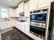 Modern kitchen with white cabinets, stainless steel appliances, and built-in double ovens at 7860 Bristol Valley Dr, Cumming, GA 30028