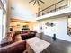 Open-concept living room featuring soaring ceilings, a leather sectional, and an open staircase at 7860 Bristol Valley Dr, Cumming, GA 30028