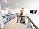 View of the upstairs loft with black metal railing, and view of staircase below at 7860 Bristol Valley Dr, Cumming, GA 30028
