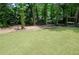 Spacious backyard featuring a lush green lawn and mature trees providing ample shade at 1241 Bethsaida Rd, Riverdale, GA 30296