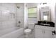 Bathroom featuring subway tile in shower, modern vanity with black countertop, and bright natural light at 1241 Bethsaida Rd, Riverdale, GA 30296
