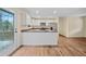 Open kitchen with white cabinetry, island, stainless appliances, and wood-look flooring at 26 Alisha Nw Cir, Cartersville, GA 30121