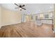 Open-concept living room with wood-look floors and ceiling fan, seamlessly flowing into the adjacent kitchen at 26 Alisha Nw Cir, Cartersville, GA 30121
