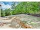 Sloping backyard under construction, featuring newly installed black retaining wall and trees at 4222 Matisse Ln, Fairburn, GA 30213