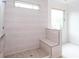 Modern bathroom shower with natural stone flooring and a shower bench under a horizontal window at 4222 Matisse Ln, Fairburn, GA 30213