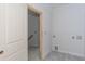 A view of a laundry room with tile floors and open doorway to a room with stairs at 4222 Matisse Ln, Fairburn, GA 30213