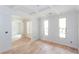 Bright, unfinished living room featuring beautiful hardwood floors, two windows, and a coffered ceiling at 4222 Matisse Ln, Fairburn, GA 30213
