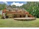 Back of house with deck, stairs, brick patio, garage and wooded area at 116 Woolsey Creek Trl, Fayetteville, GA 30215