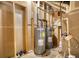 Unfinished basement with hot water tanks and exposed pipes, offers potential for conversion and utility space at 116 Woolsey Creek Trl, Fayetteville, GA 30215