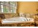 Spa-like bathroom with a relaxing jacuzzi tub and a large window view at 116 Woolsey Creek Trl, Fayetteville, GA 30215