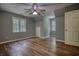 A bedroom features wood floors, natural light, neutral paint, and a ceiling fan at 116 Woolsey Creek Trl, Fayetteville, GA 30215