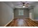 A bedroom features wood floors, natural light, neutral paint, and a ceiling fan at 116 Woolsey Creek Trl, Fayetteville, GA 30215