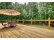 Spacious wood deck features a dining set with umbrella and wooden railing at 116 Woolsey Creek Trl, Fayetteville, GA 30215