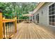 Home features a wood deck with wooden railing, dining set with umbrella, and sliding glass doors at 116 Woolsey Creek Trl, Fayetteville, GA 30215