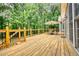 Home features a wood deck with wooden railing, dining set with umbrella, and sliding glass doors at 116 Woolsey Creek Trl, Fayetteville, GA 30215