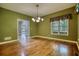 A dining room features hardwood floors, a decorative chandelier, and a large window at 116 Woolsey Creek Trl, Fayetteville, GA 30215