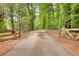 Long private driveway leading to a gated entrance, surrounded by lush greenery and mature trees at 116 Woolsey Creek Trl, Fayetteville, GA 30215