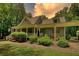 Charming single-Gathering home featuring a cozy front porch, green lawn, and lush landscaping at 116 Woolsey Creek Trl, Fayetteville, GA 30215