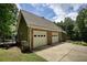 Spacious two-car garage with stone detailing and ample driveway space, surrounded by mature trees at 116 Woolsey Creek Trl, Fayetteville, GA 30215