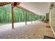 Covered brick patio with multiple support beams and access to the wooded backyard at 116 Woolsey Creek Trl, Fayetteville, GA 30215