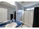 Well-lit bathroom features a vanity with blue countertop, a shower-tub combination, and a black shower curtain at 121 St Albans Way, Peachtree City, GA 30269