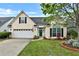 Charming home featuring a well-manicured lawn, attached garage and a beautifully landscaped front yard at 121 St Albans Way, Peachtree City, GA 30269