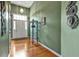 Hallway featuring hardwood flooring, stylish shelving, and sage green walls at 121 St Albans Way, Peachtree City, GA 30269