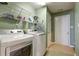 Well-equipped laundry room features white washer, dryer, and wire shelving at 121 St Albans Way, Peachtree City, GA 30269