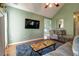 Open-concept living room features a comfortable seating, a television, and a hardwood floor at 121 St Albans Way, Peachtree City, GA 30269