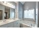 Well-lit bathroom featuring a double vanity, large mirror, and a luxurious soaking tub at 121 St Albans Way, Peachtree City, GA 30269