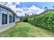 Landscaped backyard with a view of the home's sunroom and exterior at 500 Birch Forest Ln, Alpharetta, GA 30005