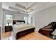 Main bedroom with hardwood floors, decorative tray ceiling, and fan at 500 Birch Forest Ln, Alpharetta, GA 30005