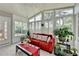 Relaxing sunroom featuring many windows, a comfy red couch, and lots of houseplants at 500 Birch Forest Ln, Alpharetta, GA 30005