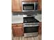 Stainless steel range with microwave, granite counters, and cherry cabinets at 563 Fieldgreen Dr, Jonesboro, GA 30238