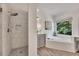 Bright bathroom with a tiled shower, soaking tub, double vanity, and window view at 7014 E Hills Way, Woodstock, GA 30189