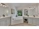 Bright bathroom with a soaking tub, double vanity, and grey cabinets at 7014 E Hills Way, Woodstock, GA 30189