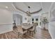 Elegant dining room featuring modern chandelier, tray ceiling, and a view of the bay window at 7014 E Hills Way, Woodstock, GA 30189