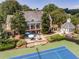 Exterior featuring beautiful landscaping, tennis courts, gazebo, and classic architecture at 7014 E Hills Way, Woodstock, GA 30189