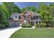 Beautiful brick home featuring lush landscaping, a two-car garage, and a well-manicured lawn at 7014 E Hills Way, Woodstock, GA 30189