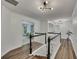 Hallway and staircase with hardwood floors and contemporary lighting at 7014 E Hills Way, Woodstock, GA 30189
