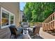 Charming outdoor seating area on the deck with wicker chairs and views of the lush green surroundings at 7014 E Hills Way, Woodstock, GA 30189