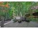 Cozy outdoor seating area featuring wood benches, cushioned seating and serene wooded views at 7014 E Hills Way, Woodstock, GA 30189