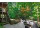 Exterior staircase leads to a tranquil outdoor retreat with natural foliage and seating at 7014 E Hills Way, Woodstock, GA 30189